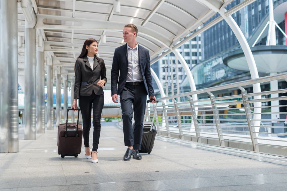Business travellers walking with luggage before a pre-booked journey